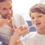 boy and father brushing teeth - Buckeye Pediatric Dentistry in Reynoldsburg