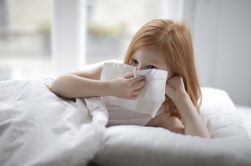 young girl sneezing