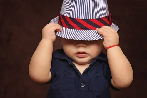 toddler hiding under hat