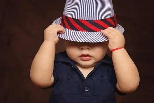 toddler hiding under hat