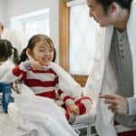 father brushes teeth with daughter